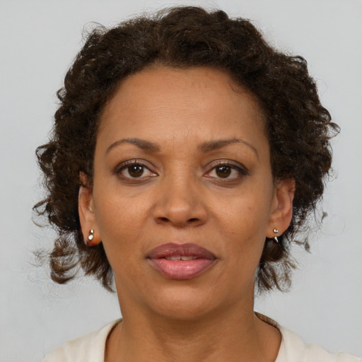 Joyful black adult female with medium  brown hair and brown eyes