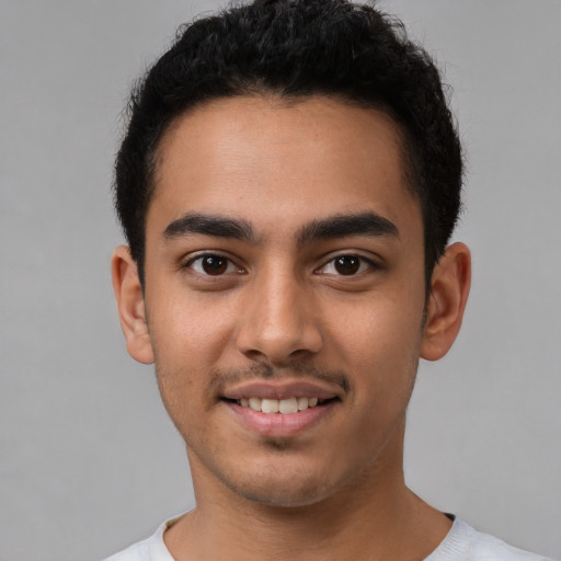 Joyful latino young-adult male with short  brown hair and brown eyes