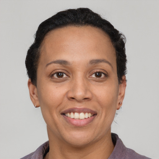 Joyful latino adult female with short  black hair and brown eyes