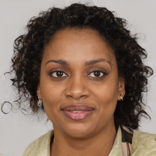 Joyful black adult female with medium  brown hair and brown eyes