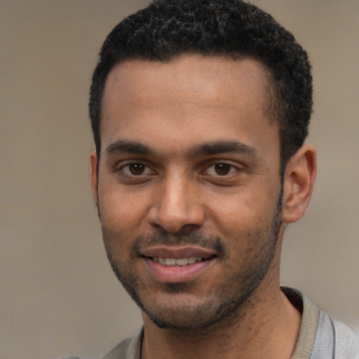 Joyful black young-adult male with short  black hair and brown eyes