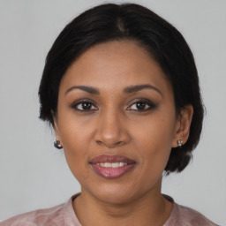 Joyful black adult female with medium  brown hair and brown eyes