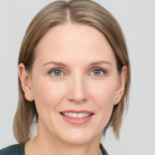 Joyful white young-adult female with medium  brown hair and blue eyes