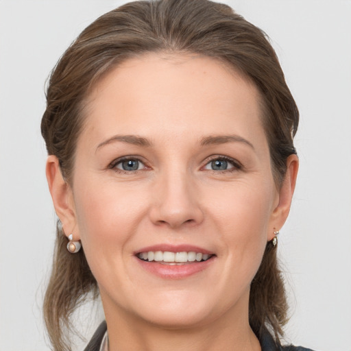 Joyful white young-adult female with medium  brown hair and grey eyes