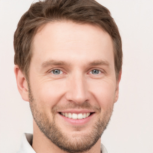 Joyful white young-adult male with short  brown hair and grey eyes