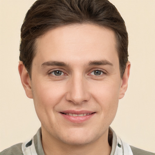 Joyful white young-adult male with short  brown hair and grey eyes