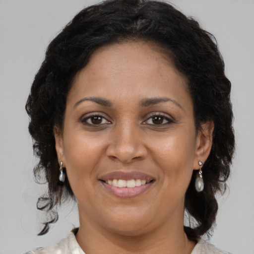 Joyful black adult female with medium  brown hair and brown eyes