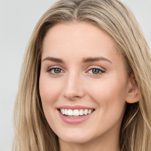 Joyful white young-adult female with long  brown hair and blue eyes