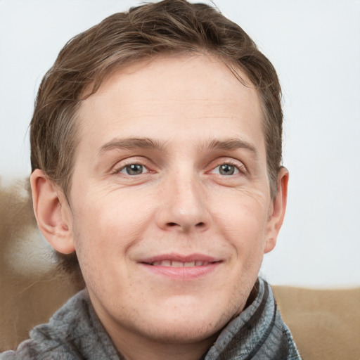 Joyful white adult male with short  brown hair and grey eyes