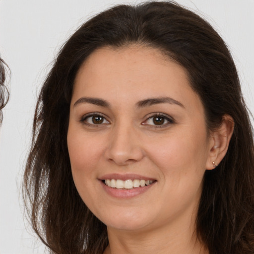 Joyful white young-adult female with long  brown hair and brown eyes