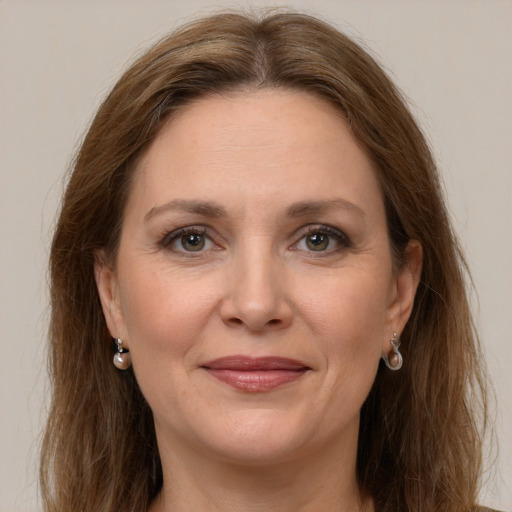 Joyful white adult female with long  brown hair and grey eyes