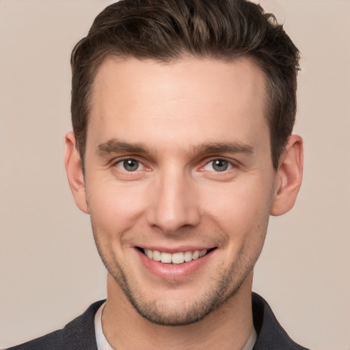 Joyful white young-adult male with short  brown hair and grey eyes