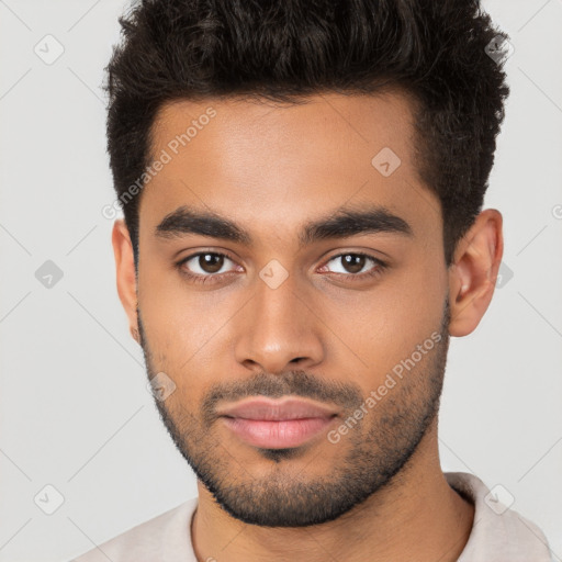 Joyful latino young-adult male with short  brown hair and brown eyes