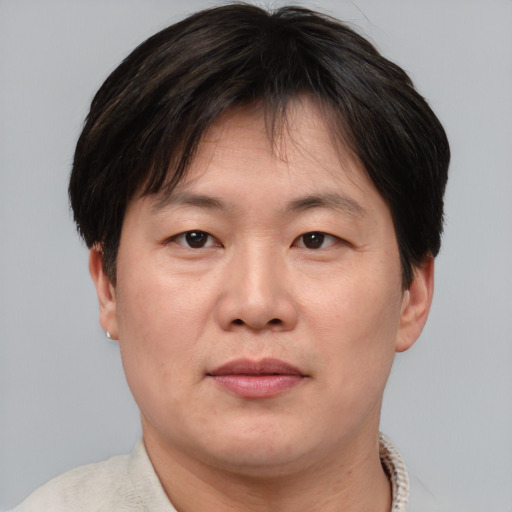 Joyful asian adult male with short  brown hair and brown eyes