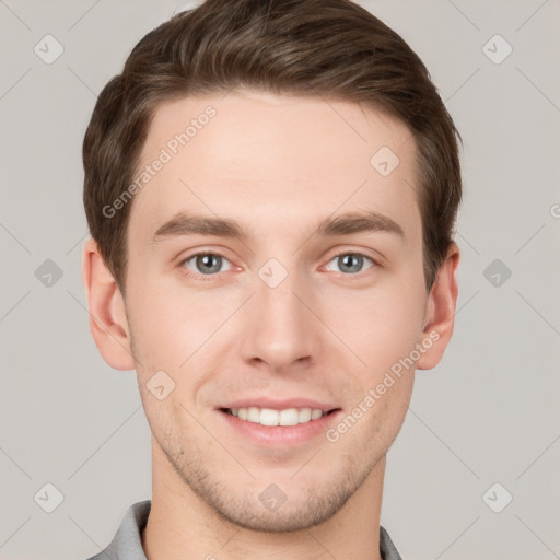 Joyful white young-adult male with short  brown hair and grey eyes