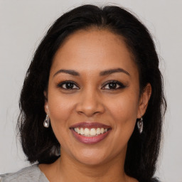 Joyful latino young-adult female with medium  brown hair and brown eyes