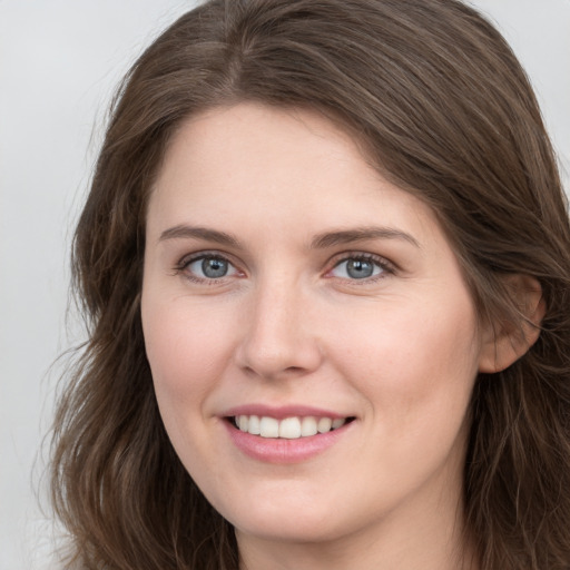 Joyful white young-adult female with long  brown hair and grey eyes