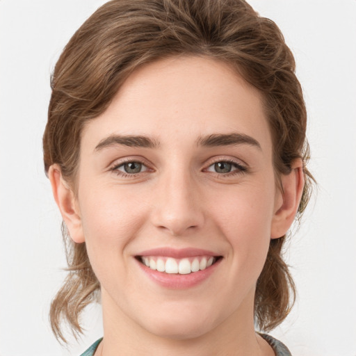 Joyful white young-adult female with medium  brown hair and green eyes