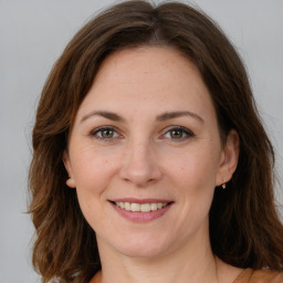 Joyful white young-adult female with long  brown hair and green eyes