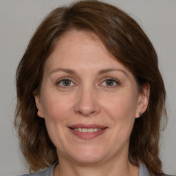 Joyful white adult female with medium  brown hair and grey eyes