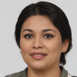 Joyful latino young-adult female with medium  brown hair and brown eyes