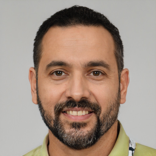 Joyful latino adult male with short  black hair and brown eyes
