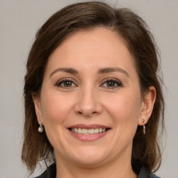 Joyful white adult female with medium  brown hair and grey eyes