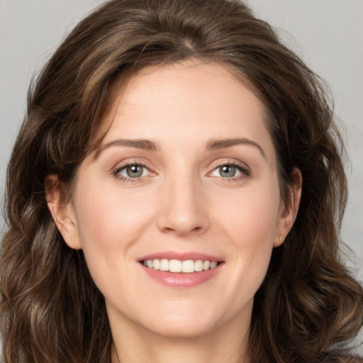 Joyful white young-adult female with long  brown hair and green eyes