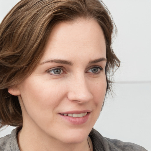 Joyful white young-adult female with medium  brown hair and blue eyes