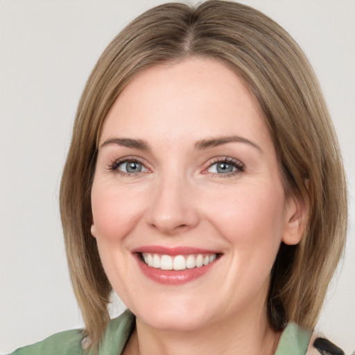 Joyful white young-adult female with medium  brown hair and green eyes