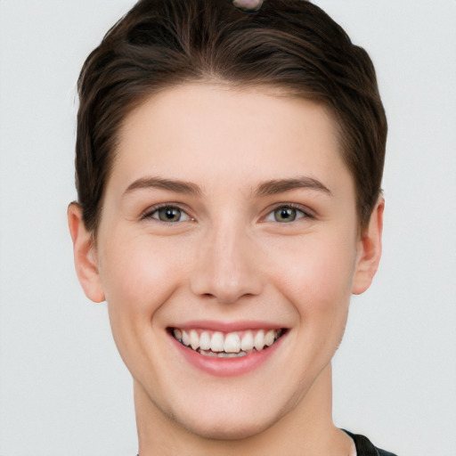 Joyful white young-adult female with short  brown hair and grey eyes