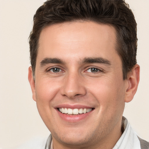 Joyful white young-adult male with short  brown hair and brown eyes