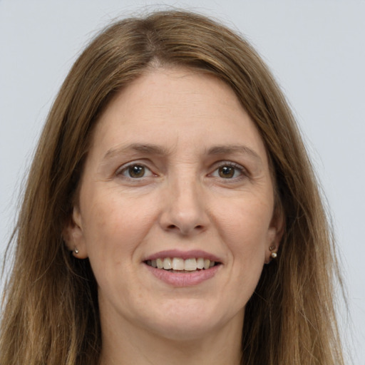 Joyful white adult female with long  brown hair and grey eyes