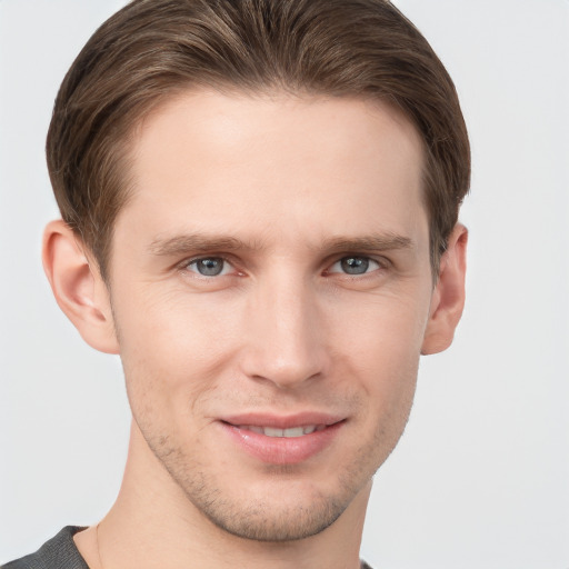 Joyful white young-adult male with short  brown hair and grey eyes