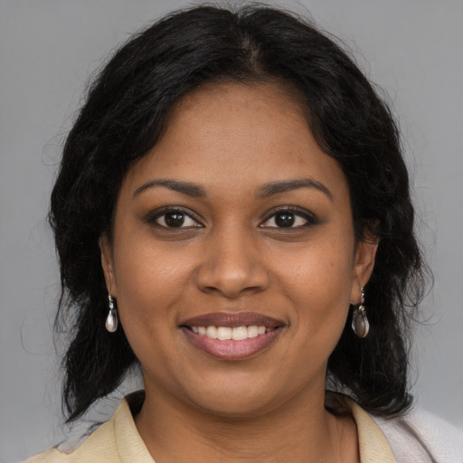 Joyful black young-adult female with long  brown hair and brown eyes