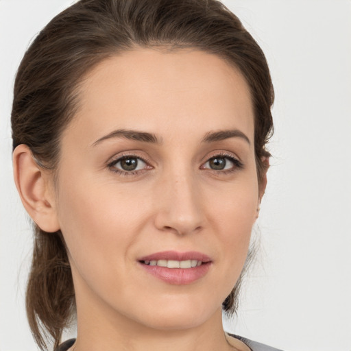 Joyful white young-adult female with medium  brown hair and grey eyes