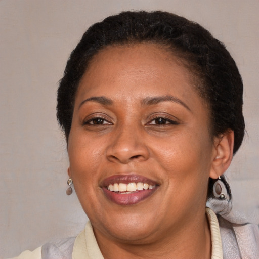 Joyful latino adult female with medium  brown hair and brown eyes