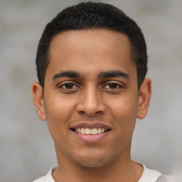 Joyful latino young-adult male with short  brown hair and brown eyes