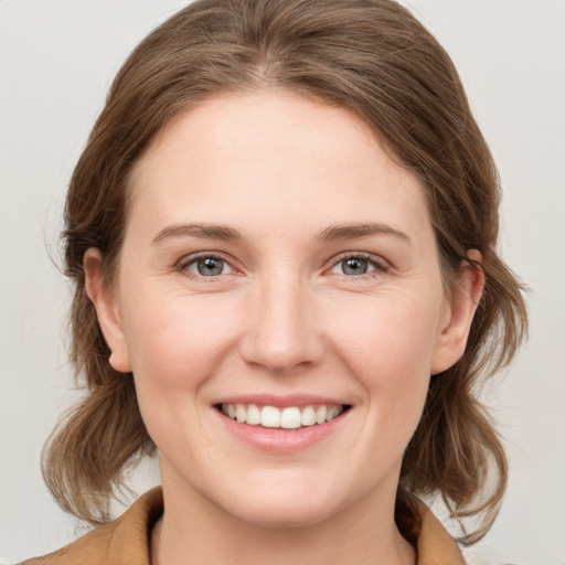 Joyful white young-adult female with medium  brown hair and grey eyes