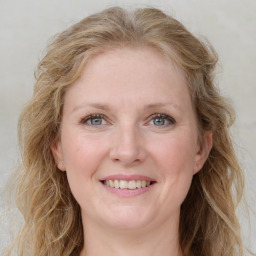 Joyful white young-adult female with long  brown hair and blue eyes