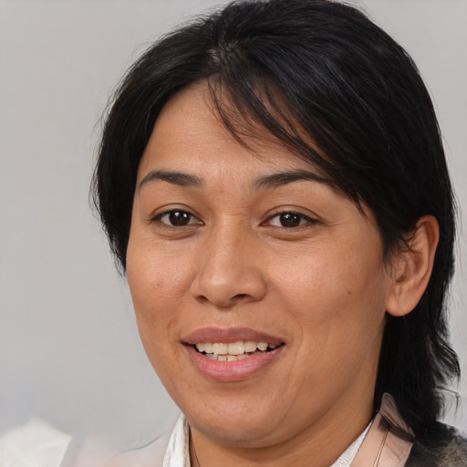 Joyful asian adult female with medium  brown hair and brown eyes