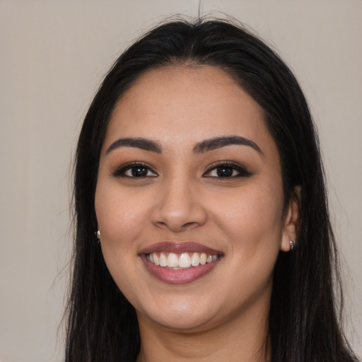 Joyful latino young-adult female with long  black hair and brown eyes