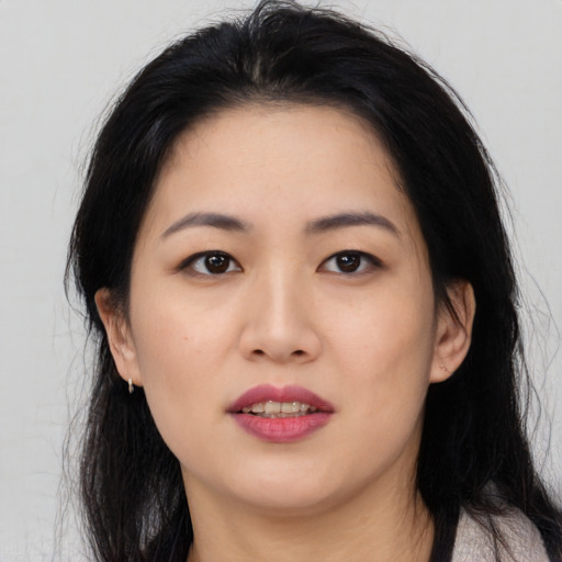 Joyful asian young-adult female with long  black hair and brown eyes