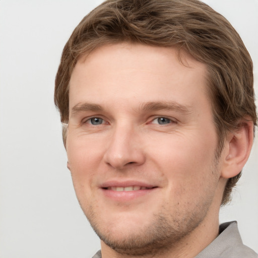 Joyful white young-adult male with short  brown hair and grey eyes