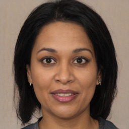 Joyful latino adult female with medium  brown hair and brown eyes