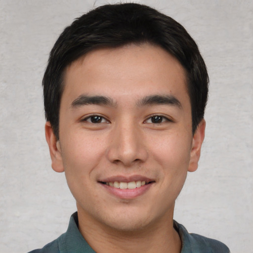 Joyful asian young-adult male with short  brown hair and brown eyes