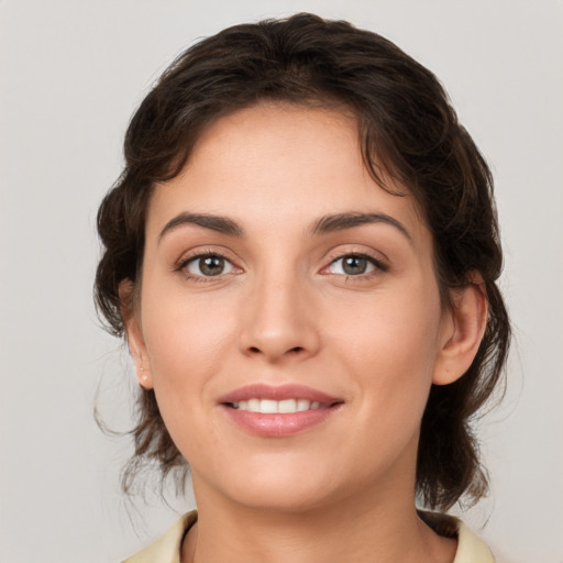 Joyful white young-adult female with medium  brown hair and grey eyes