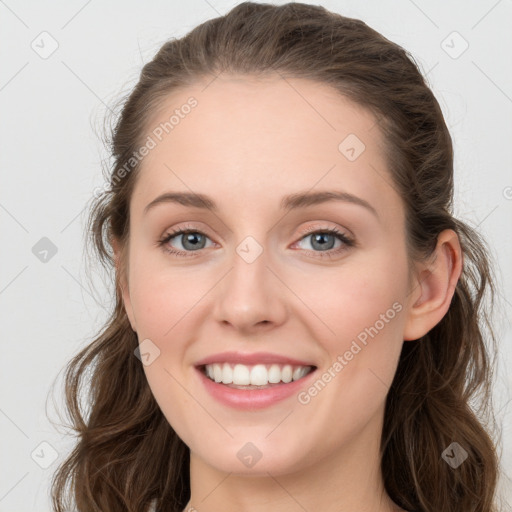 Joyful white young-adult female with long  brown hair and blue eyes