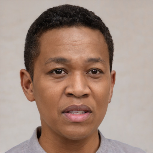 Joyful black adult male with short  black hair and brown eyes