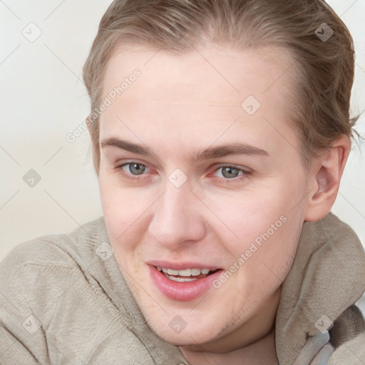 Joyful white young-adult female with short  brown hair and blue eyes